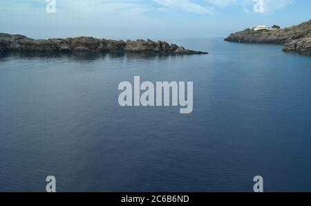 Loutro villaggio, Creta, Grecia. Mare della baia e scogliere basse circostanti. Calma, tranquilla vista panoramica. Aspetto orizzontale. Cielo blu e spazio copia. Foto Stock