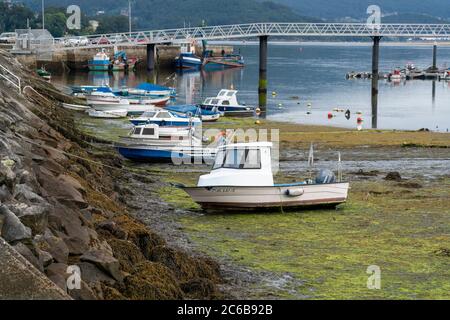 Le barche si sono arenate in bassa marea in un porto di Redondela, Pontevedra, Galizia, Spagna, Europa Foto Stock