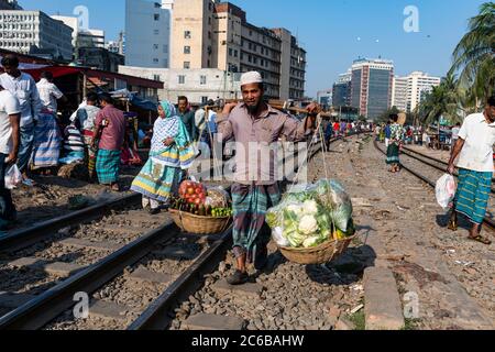 Venditore di strada sulle piste ferroviarie che attraversano il Bazaar di Kawran, Dhaka, Bangladesh, Asia Foto Stock