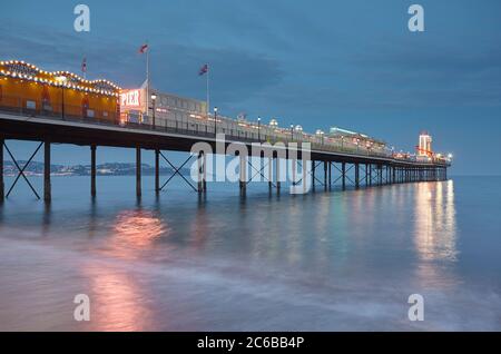 Una vista crepuscolo di un classico molo sul mare, Paignton Pier, Torbay, Devon, Inghilterra, Regno Unito, Europa Foto Stock