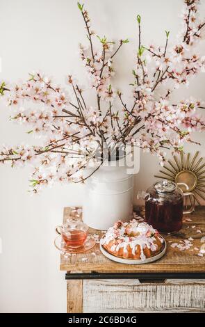 Torta senza glutine e tè sotto rami fioriti Foto Stock