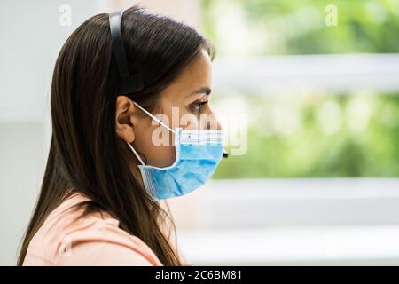 Operatore telefonico di Call Center in ufficio con maschera facciale Foto Stock