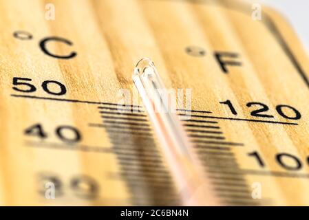 Un macro-shot di un classico termometro in legno che mostra una temperatura superiore a 50 gradi Celsius, 122 gradi Fahrenheit. Foto Stock