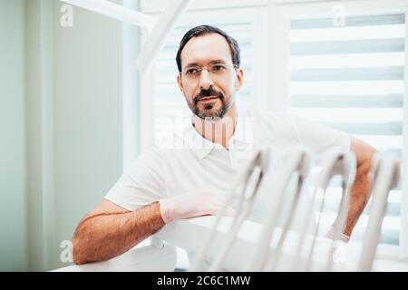 Minsk, Bielorussia - Giugno 11, 2020: Dentista professionista in un ufficio odontoiatrico in colori brillanti è pronto a ricevere un paziente per il trattamento del mal di denti Foto Stock