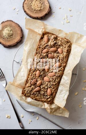 Pasticceria vegetariana senza glutine senza zucchero fatta in casa. Pane di farinata d'avena con semi e noci appena sfornati in carta, servito con semi interi di lino e amaranto Foto Stock