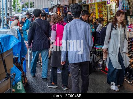 Folla di persone che passeggiano al mercato esterno di Tsukiji, lungo la strada stretta, Tokyo, Giappone Foto Stock