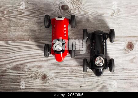 Auto giocattolo d'epoca rosse e nere su una superficie di legno Foto Stock