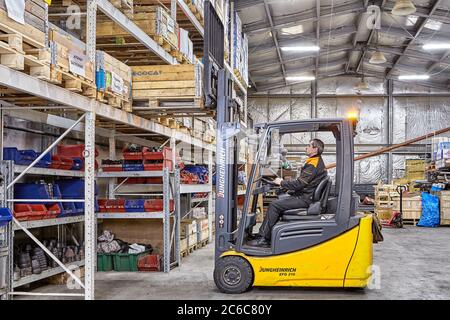 San Pietroburgo, Russia - 24 dicembre 2018: Un carrello elevatore a forche rimuove un pallet di merci da un rack in un magazzino di attrezzature di fabbrica. Sistema di stoccaggio a. Foto Stock