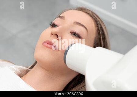 Dentista prende un x-ray foto del dente. Paziente sdraiato su una sedia. Per le cure dentarie concept Foto Stock