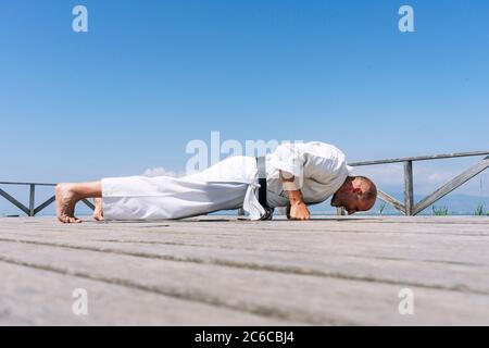 Karate uomo in piedi, poggia tutto il vostro peso sui pugni Foto Stock