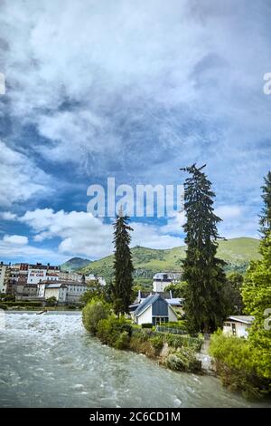 Lourdes, Francia - 18 giugno 2018: Alberi di abete rosso alto sulla riva di un fiume di montagna veloce Gave de Pau Foto Stock