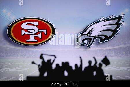 San Francisco 49ers vs. Philadelphia Eagles. Supporto dei fan su NFL Game. Silhouette di tifosi, grande schermo con due rivali in background. Foto Stock