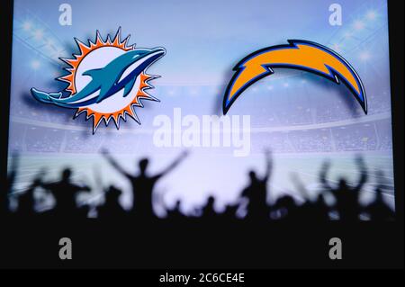 Miami Dolphins vs Los Angeles Chargers. Supporto dei fan su NFL Game. Silhouette di tifosi, grande schermo con due rivali in background. Foto Stock