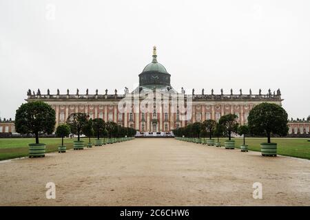 Sala degli alberi con un palazzo in fondo in una giornata nuvolosa senza persone. (Sanssouci Potsdam Park) Foto Stock