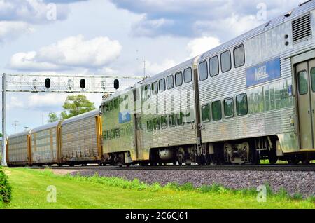 Winfield, Illinois, Stati Uniti. Un treno per pendolari Metra in arrivo destinato a Chicago passa attraverso un treno merci Union Pacific in direzione ovest. Foto Stock