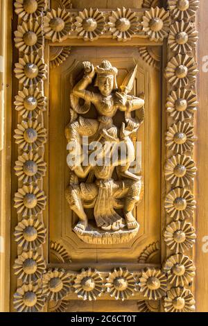 Un dettaglio da vicino di sculture in legno su un pannello di una porta di un antico tempio a Bagan, Myanmar Foto Stock