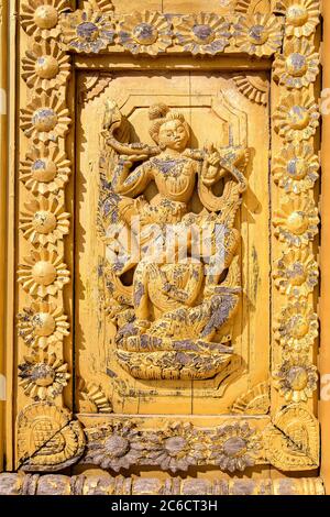Un dettaglio da vicino di sculture in legno su un pannello di una porta di un antico tempio a Bagan, Myanmar Foto Stock