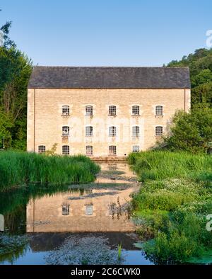 Belvedere Mill riflesso nel fiume frome nella luce del primo mattino. Chalford, Cotswolds, Stroud, Gloucestershire, Inghilterra Foto Stock