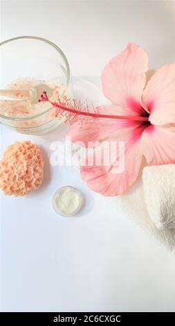 Ambiente Spa e composizione di sfondo Spa con fiore rosa ibisco su sfondo bianco. Spazio di copia. Asciugamano, candele, fiori, pietre. Massaggio, orie Foto Stock