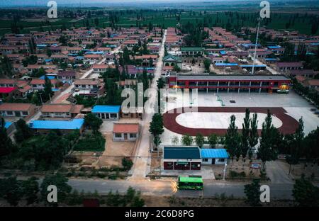 (200708) -- YINCHUAN, 8 luglio 2020 (Xinhua) -- Foto aerea scattata il 30 giugno 2020 mostra un autobus che trasporta i pickers di bacca di goji ad una base di piantagione nella contea di Zhongning, regione Autonoma di Ningxia Hui della Cina nord-occidentale. Nel villaggio di Kaiyuan del distretto di Hongsibao, gruppi di donne si alzano presto per prendere gli autobus per iniziare il loro lavoro quotidiano, raccogliendo la bacca di goji, alla base di piantagione della bacca di Zhonggning goji che è 10 km via. Hongsibao è una grande comunità di ecomigration, dove i residenti che in precedenza vivono in aree vulnerabili dal punto di vista ambientale sono rilocati. Come la stagione di raccolta di frutti di bosco di goji di quest'anno viene, circa 22,800 andare Foto Stock