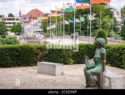 Rheinfelden, AG / Svizzera - 6 luglio 2020: Parco cittadino con statua e ponte verso la Germania sullo sfondo Foto Stock