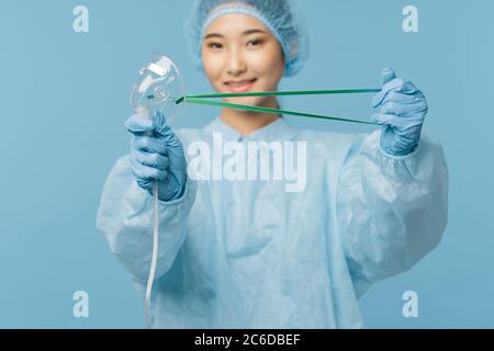 Medico professionista con una maschera medica in mano sorridente Foto Stock