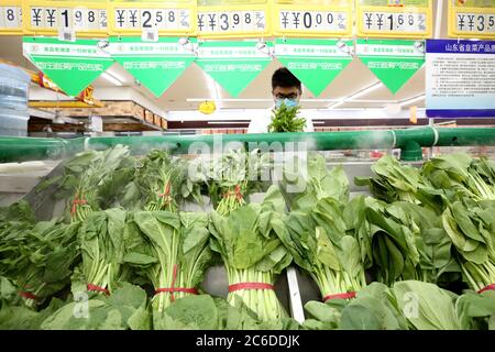 Zaozhuang, provincia cinese di Shandong. 9 luglio 2020. Un cittadino seleziona le verdure in un supermercato nella città di Zaozhuang, nella provincia di Shandong della Cina orientale, il 9 luglio 2020. L'indice dei prezzi al consumo (CPI), il principale indicatore di inflazione, è cresciuto del 2.5% l'anno scorso, espandendosi dal guadagno del 2.4% di maggio, secondo i dati del National Bureau of Statistics. Credit: Sun Zhongzhe/Xinhua/Alamy Live News Foto Stock