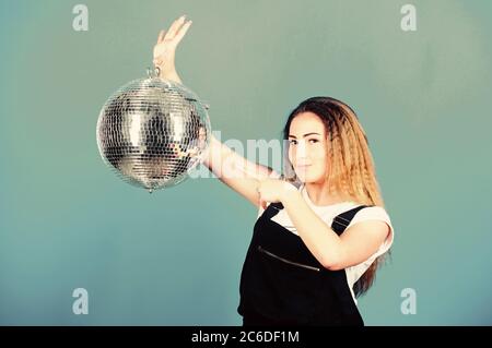 Invito alla festa. Ragazza di compleanno. Gli specchi riflettenti discoteca luci di atmosfera. Concorso di ballo. Scuola di ballo. Allegro woman dancing insegnante tenere palla da discoteca. Come circa la parte. Night club. Musica retrò. Foto Stock