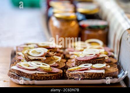 Pane con carne, salsiccia e cipolle su un vassoio in un cafe' all'aperto. Spuntini veloci., messa a fuoco selettiva - immagine Foto Stock