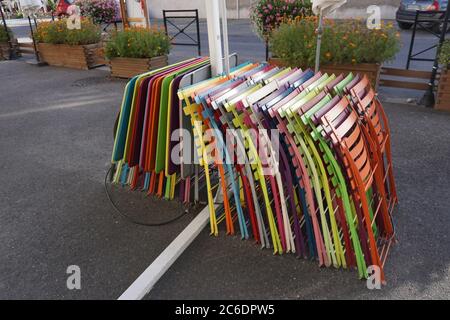 tavoli e sedie colorati accatastati all'aperto Foto Stock