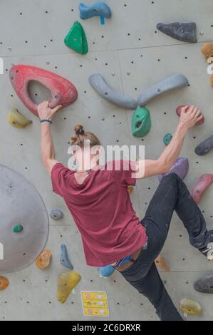 Arrampicata di Young Man presso UN muro di arrampicata ad Amsterdam Olanda 2018 Foto Stock