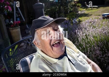 Anziano nei suoi anni '80 godendosi seduto al sole, Inghilterra, Regno Unito Foto Stock