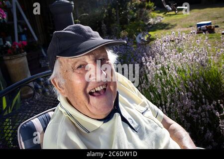 Anziano nei suoi anni '80 godendosi seduto al sole, Inghilterra, Regno Unito Foto Stock