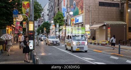 Veicolo nella strada del quartiere di Sangenjaya, Tokyo, Giappone al tramonto. Foto Stock