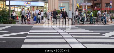 Pedone che attraversa la strada del quartiere di Sangenjaya, Tokyo, Giappone al tramonto. Foto Stock