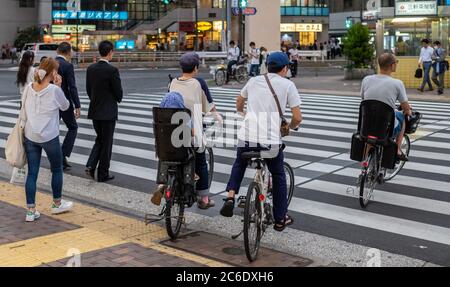 Pedone che attraversa la strada del quartiere di Sangenjaya, Tokyo, Giappone al tramonto. Foto Stock