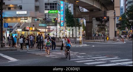 Pedone che attraversa la strada del quartiere di Sangenjaya, Tokyo, Giappone al tramonto. Foto Stock