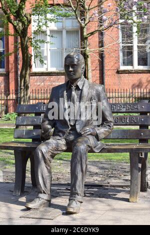 Monumento commemorativo di Alan Turing, Sackville Park, Manchester, Regno Unito. Statua seduta su una panchina nel parco. Foto Stock