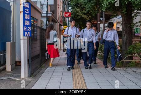 Gli studenti camminano di notte nella strada laterale di Sangenjaya, Tokyo, Giappone. Foto Stock