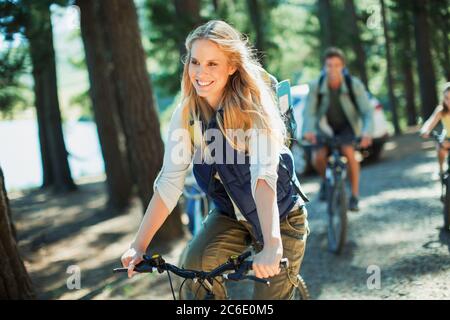 Donna sorridente in bicicletta a cavallo in legno Foto Stock