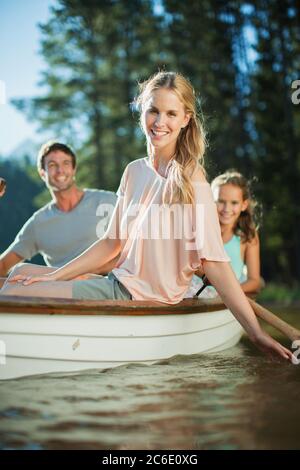 Sorridente famiglia in barca a remi sul lago Foto Stock