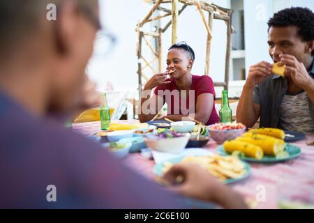 I giovani amici mangiano la cena sul patio Foto Stock