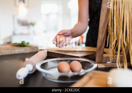 Donna che prepara pasta fresca fatta in casa in cucina Foto Stock