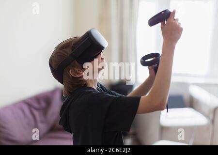 Ragazzo che gioca a un videogioco con occhiali VRS Foto Stock