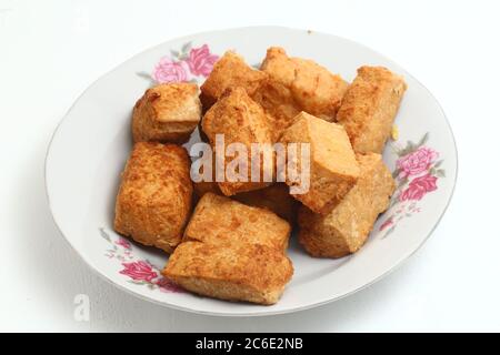 Tofu o Tahu di cibo fritto tradizionale indonesiano isolato su sfondo bianco Foto Stock