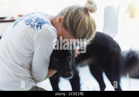 Affettuosa donna abbracciando cane Foto Stock