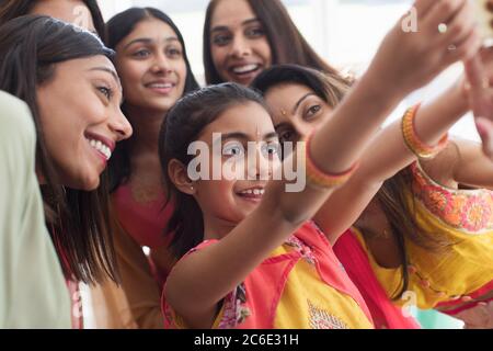 Sorridendo le donne e le ragazze indiane in saris che prendono selfie Foto Stock
