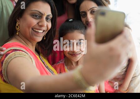Felice indiano donne in bindis e saris prendendo selfie con il telefono della macchina fotografica Foto Stock