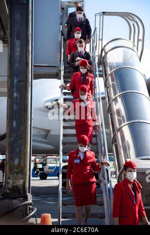 Kiev, Ucraina - 1 luglio 2020: Personale - capitani, piloti e assistenti di volo in maschere mediche. Aereo sulla piattaforma di Boryspil International Foto Stock