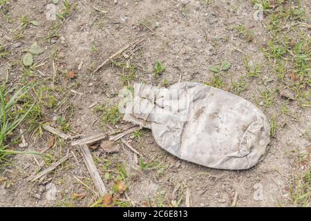 Bottiglia di bibite analcoliche vuota sul lato di una tranquilla strada di campagna. Esempio di inquinamento plastico nelle campagne britanniche, rifiuti di plastica monouso, rifiuti di plastica Foto Stock